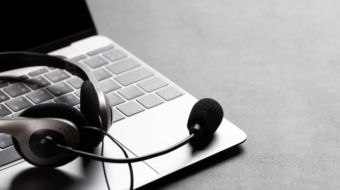 Office desk with headset and laptop. Remote office and work from home concept. With copy space